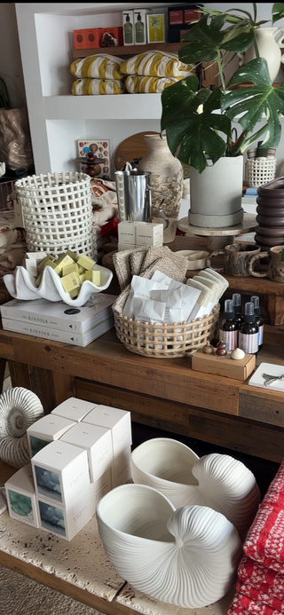 Decorative items on a wooden shelf including plants, baskets, and ceramic pieces.